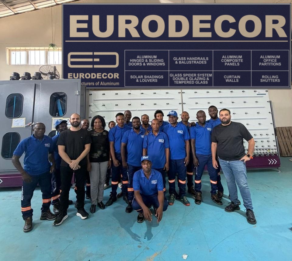 The Euro Decor team in blue under the EURODECOR banner in the factory