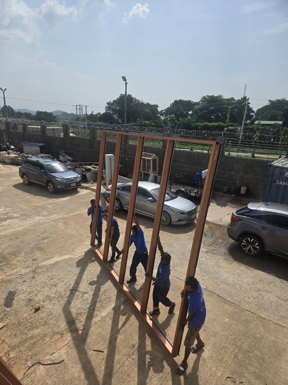 Five of the crew walking the large bronze frame upright